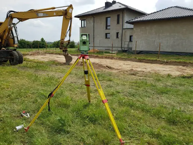 Geodeta mierzy teren pod budowę. Zastanawiasz się, ile kosztuje podział domu przez geodetę?