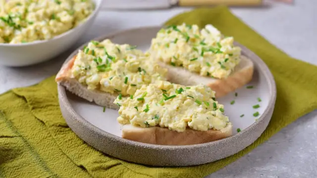 Pyszna pasta jajeczna ze szczypiorkiem na kromkach chleba. Idealna na śniadanie lub przekąskę.