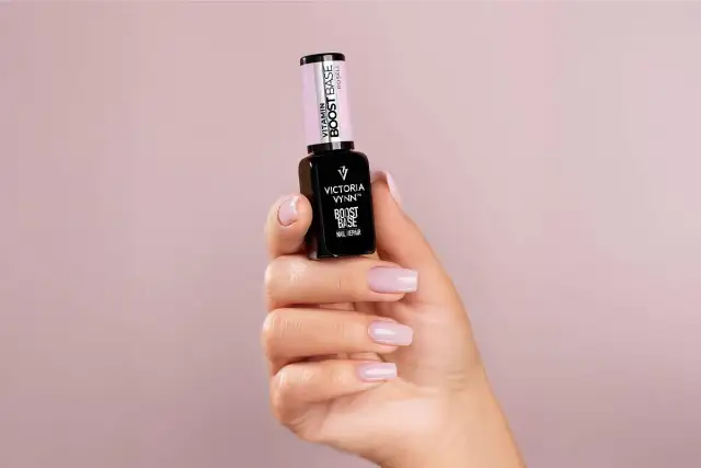 Dłoń prezentuje lakier Victoria Vynn Boost Base. Zastanawiasz się, najpierw primer czy baza? Ten produkt to idealny wybór na start.