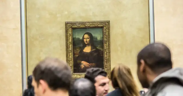 Słynny obraz Mona Lisa da Vinci, otoczony tłumem widzów w muzeum.