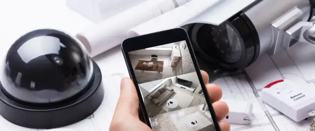 Chcesz wiedzieć, jak ustawić kamery monitoringu? Na zdjęciu widać sprzęt i podgląd na telefonie.