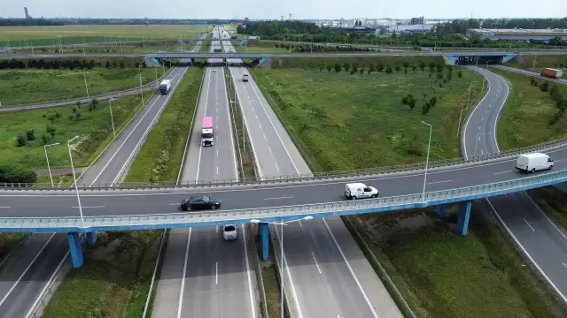 Widok z lotu ptaka na wielopoziomowy węzeł autostradowy z ruchem samochodowym i ciężarowym.