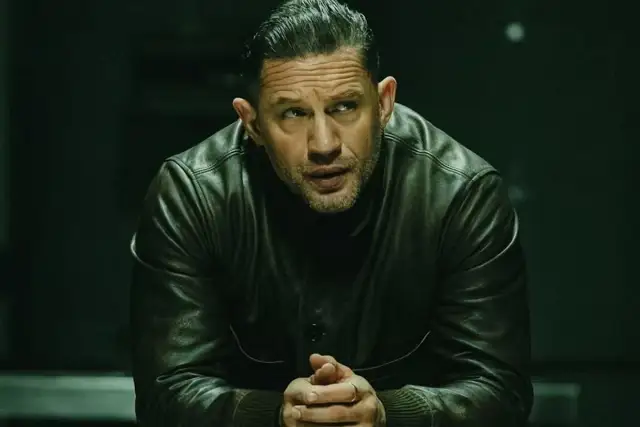 Tom Hardy w skórzanej kurtce, członek obsady "Strefy gangsterów", spogląda w bok z zamyśloną miną.