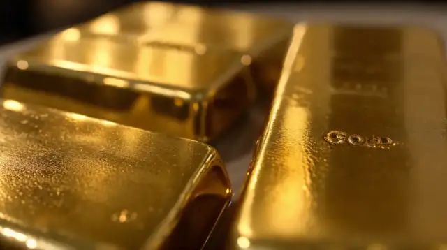 Trzy błyszczące sztabki złota, jedna z napisem "GOLD".