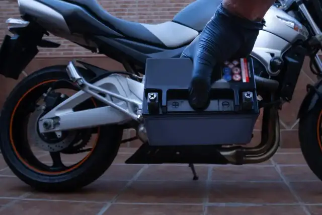 Rękawiczka zakłada nowy akumulator do motocykla. Zastanawiasz się, jaki akumulator do motocykla będzie najlepszy?