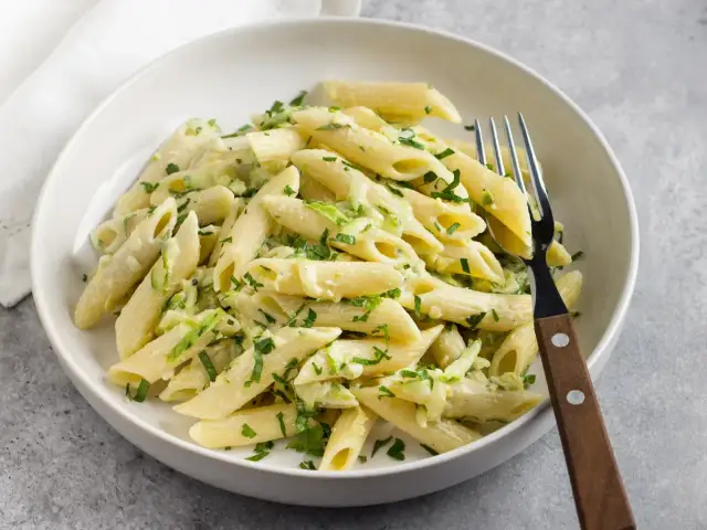Makaron penne z cukinią i natką pietruszki w białym sosie.