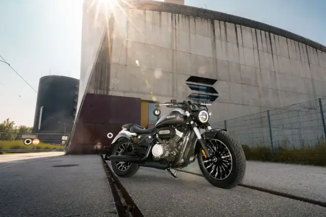 Czarny motocykl typu chopper 125 na tle nowoczesnego budynku.