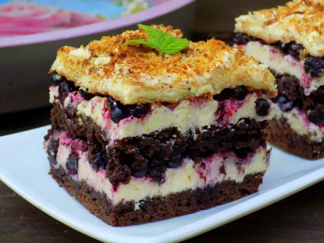 Pyszne ciasto z kaszą manną, czekoladą i jagodami, przełożone kremem.