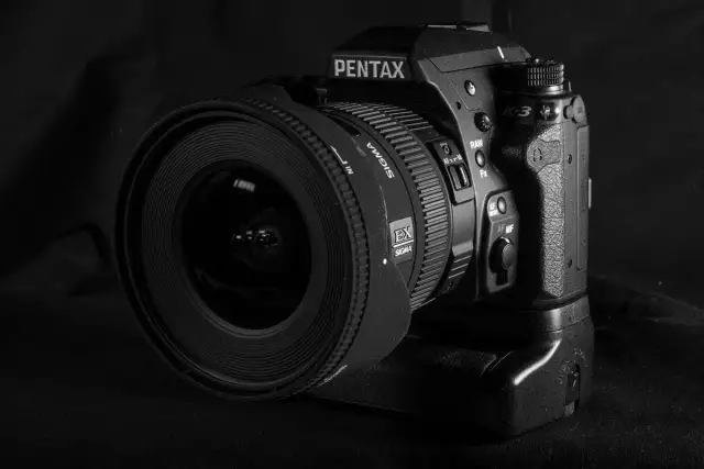 Czarno-białe zdjęcie lustrzanki Pentax K-3 z obiektywem Sigma.