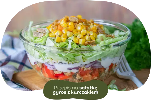 Warstwowa sałatka gyros z kurczakiem, pomidorami, cebulą i kukurydzą. Idealna, gdy zastanawiasz się, czy sałatkę gyros można zrobić dzień wcześniej.