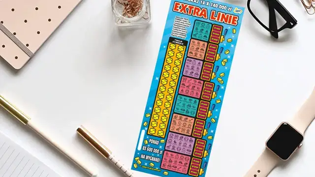 Zdrapka "Extra Linie" leży obok notatnika i okularów. Czy uda się zdrapać wygraną?