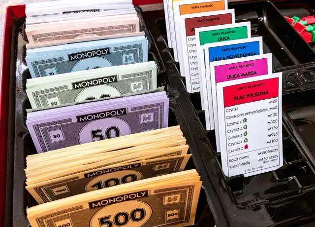 Monopolowe banknoty o nominałach 10, 20, 50, 100 i 500 oraz karty własności nieruchomości.