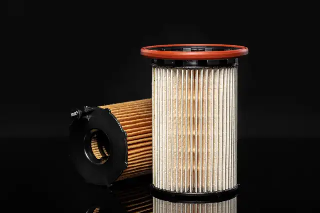 Dwa filtry paliwa, jeden pionowo z pomarańczową uszczelką, drugi leżący. Gdzie jest filtr paliwa? Tutaj!