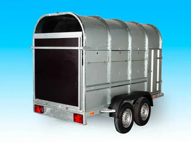 Nowa przyczepa do bydła, solidna, metalowa, z podwójnymi osiami i drzwiami z tyłu.