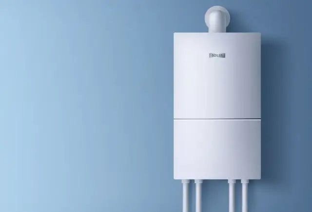 Nowoczesny, energooszczędny bojler elektryczny 50l na niebieskiej ścianie.