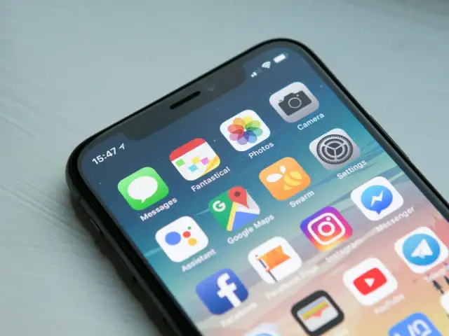 Ekran iPhone z ikonami aplikacji. Dowiedz się, jak wyłączyć aplikacje w tle iPhone, aby oszczędzać baterię.