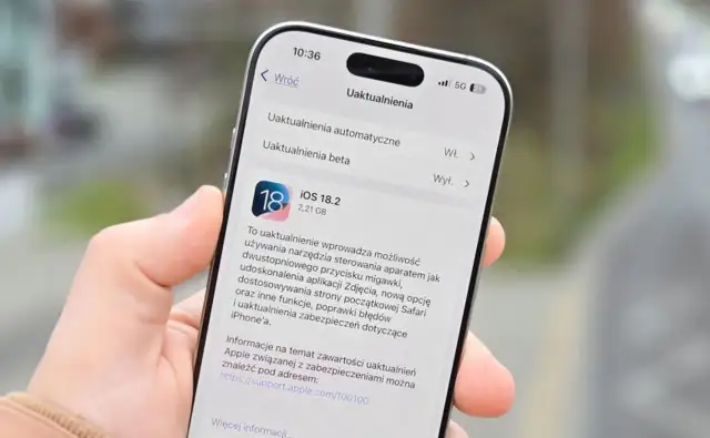 Dłoń trzyma iPhone'a z otwartym ekranem aktualizacji iOS 18.2.