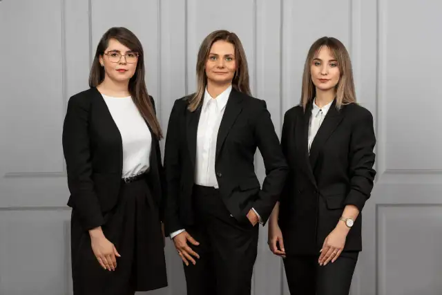 Trzy kobiety w czarnych garniturach. Zastanawiasz się, ile bierze adwokat za reprezentowanie w sądzie?
