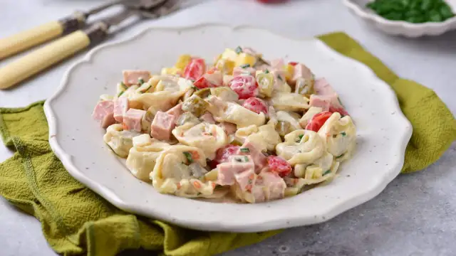 Sałatka z tortellini z szynką, pomidorkami i ogórkiem konserwowym w kremowym sosie.