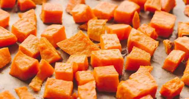 Pokrojone bataty, gotowe do pieczenia. Ich pomarańczowy kolor sugeruje bogactwo beta-karotenu, a bataty właściwości odżywcze czynią je zdrowym dodatkiem do diety.