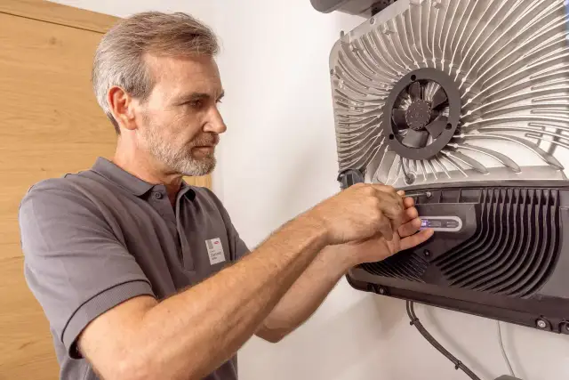 Technik ustawia falownik Fronius. Dowiedz się, jak połączyć się z falownikiem Fronius, wykonując te kroki.
