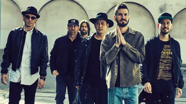 Sechs Männer der Band Linkin Park stehen nebeneinander, einige tragen Hüte und Jacken.