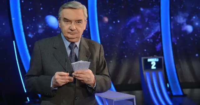 Tadeusz Sznuk, prowadzący Jeden z dziesięciu, trzyma karty z numerami.