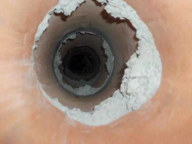 Widok wnętrza komina z osadem. Zastanawiasz się, ile kosztuje frezowanie komina?