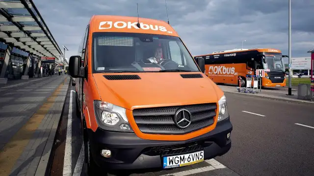 Pomarańczowy bus OKBUS czeka na pasażerów. Zastanawiasz się, ile kosztuje bus z Łodzi do Uniejowa? Sprawdź ofertę przewoźnika.