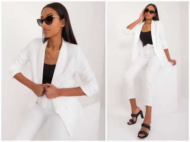 Elegancki biały żakiet w stylizacjach. Kobieta w białym garniturze i czarnym topie, uzupełnionym złotym łańcuszkiem i okularami.