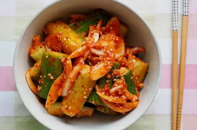 Miseczka pełna pikantnych ogórków po chińsku, z dodatkiem cebuli i sezamu.