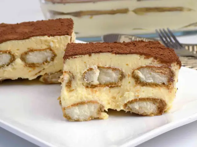 Pyszne tiramisu bez pieczenia, warstwowe, z biszkoptami i kremem, posypane kakao. Idealne na deser.