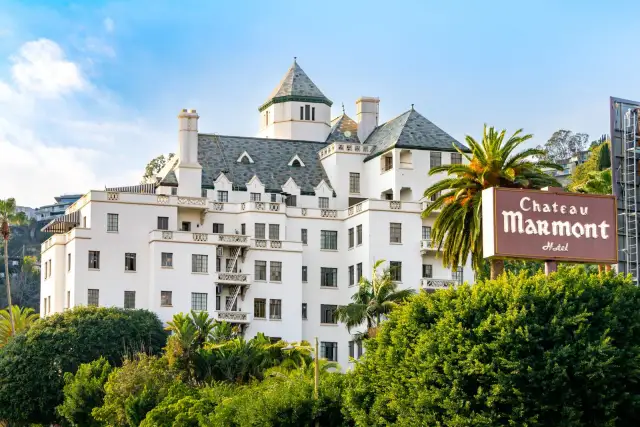 Chateau Marmont, miejsce, gdzie może mieszkać Keanu Reeves, to biały hotel z zielonym dachem i palmami.