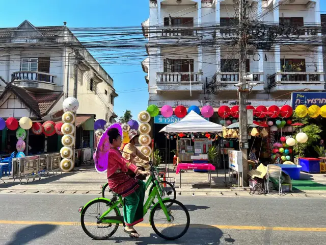 Kolorowe parasolki i tradycyjne stroje w Chiang Mai, gdzie nocować, tworzą festiwalową atmosferę.