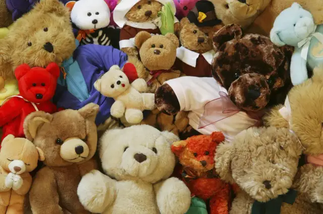 Stos pluszowych misiów w różnych kolorach i rozmiarach.
