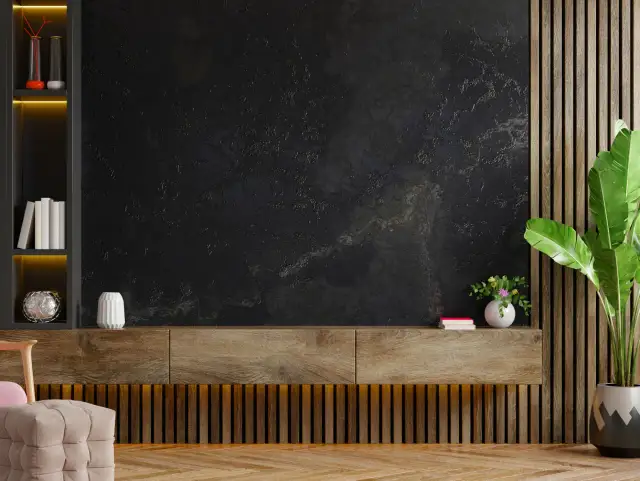 Nowoczesna ściana z tynkiem dekoracyjnym, drewniana szafka i rośliny. Dowiedz się, ile kosztuje położenie tynku dekoracyjnego.