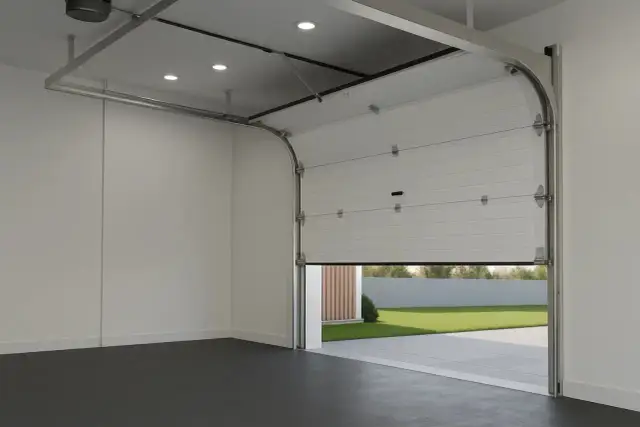 Montaż bramy garażowej w nowoczesnym garażu. Biała, segmentowa brama uchylona, odsłaniająca zielony trawnik i podjazd.