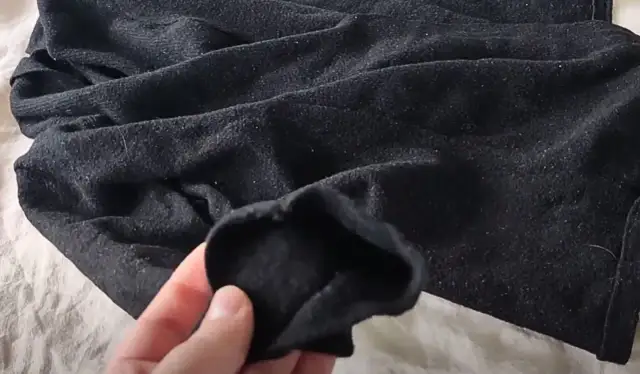 Czarny, sfilcowany sweter z widocznymi kuleczkami. Zastanawiasz się, sfilcowany sweter co zrobić?