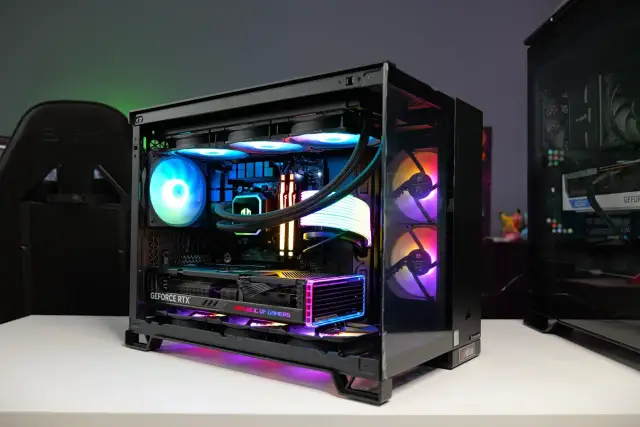 Wnętrze komputera z podświetlanymi wentylatorami i kartą graficzną GeForce RTX. Widać wiele części komputera, w tym chłodzenie procesora i pamięć RAM.