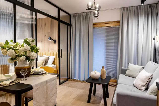 Długi salon: 10 trików, by optycznie go skrócić i urządzić!