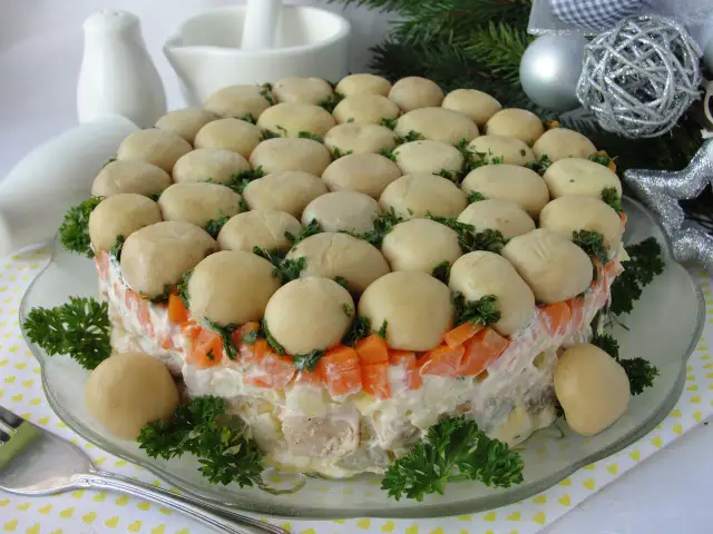 Wykwintna sałatka leśna polana, udekorowana całymi pieczarkami i natką pietruszki, prezentuje się apetycznie.