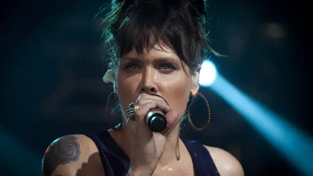 Beth Hart z tatuażem na ramieniu, w okrągłych kolczykach, śpiewa do mikrofonu. Choć nie widać jej dzieci, jej energia na scenie jest jak dla nich.