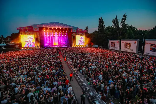 Koncert na Orange Warsaw Festival z tłumem widzów i artystą na telebimie.