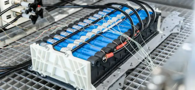 Baterie litowo-jonowe w samochodzie elektrycznym, z widocznymi przewodami i złączami, ilustrujące sposoby łączenia przewodów elektrycznych w samochodzie.