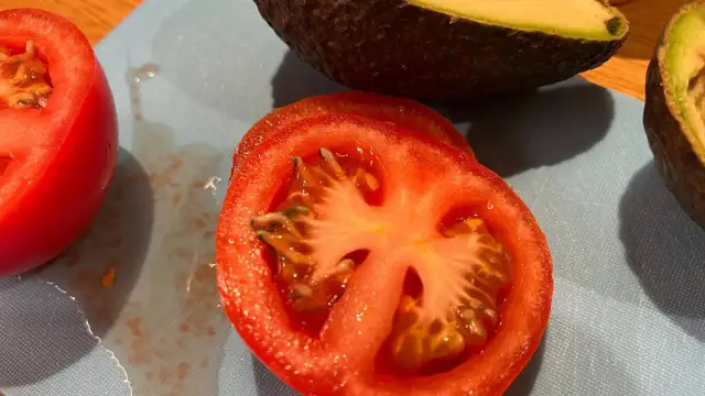 Krojone pomidory i awokado na desce. Czy króliki mogą jeść pomidory? To pytanie nurtuje wielu właścicieli tych zwierząt.