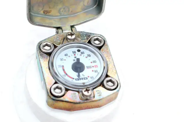 Metalowa obudowa z otwartą klapką, w której znajduje się manometr. To element, gdzie licznik gazu w bloku pokazuje odczyt.