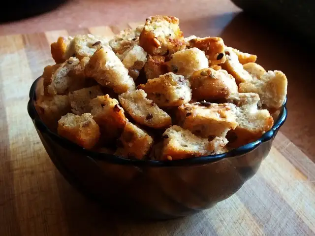 Miseczka pełna chrupiących grzanek, idealnych do zupy. Proste i pyszne, jak zrobić grzanki do zupy w domu.