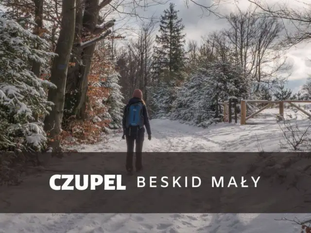 Kobieta z plecakiem idzie zimowym szlakiem w Beskidzie Małym. To czupel najładniejszy szlak, pokryty śniegiem.