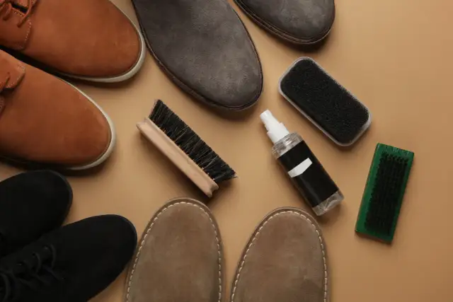 Zamszowe buty w różnych kolorach i akcesoria do ich pielęgnacji: szczotki i spray.