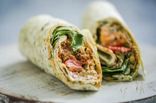 Pyszna tortilla z kurczakiem, świeżymi warzywami i kremowym sosem, idealna na szybki lunch.